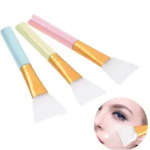 Tres brochas para mascarilla con mango plástico de colores azul, verde claro y rosado, cerdas de silicona blanca y uso facial visible en miniatura.